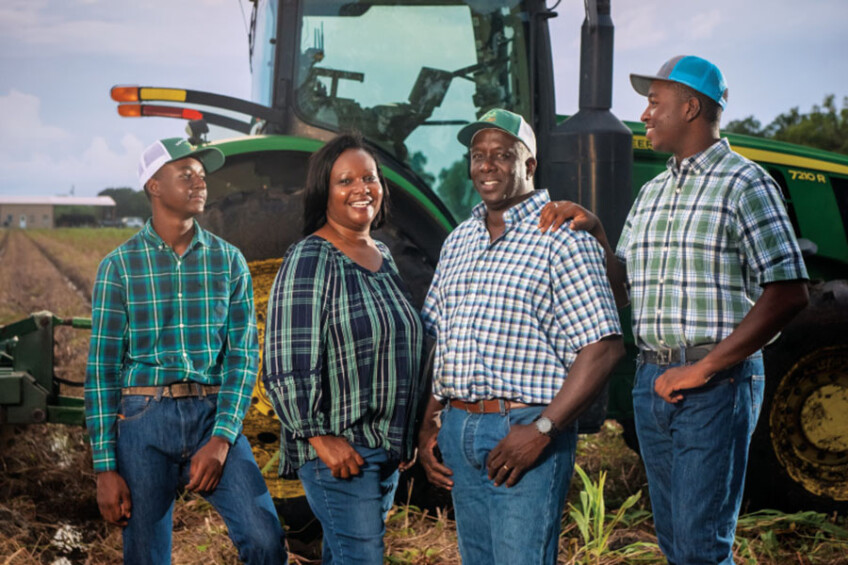 April and Steve Singleton with their sons, Brett and Lane, in front of a tractor on their potato farm.