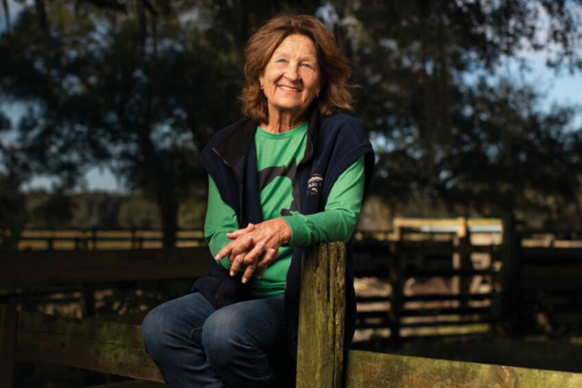Lynn Mills sits on a fence row on her family's ranch