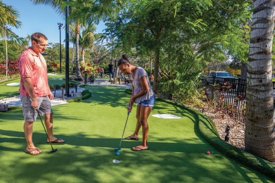 Woman playing mini golf at Lighthouse Cove Adventure Golf