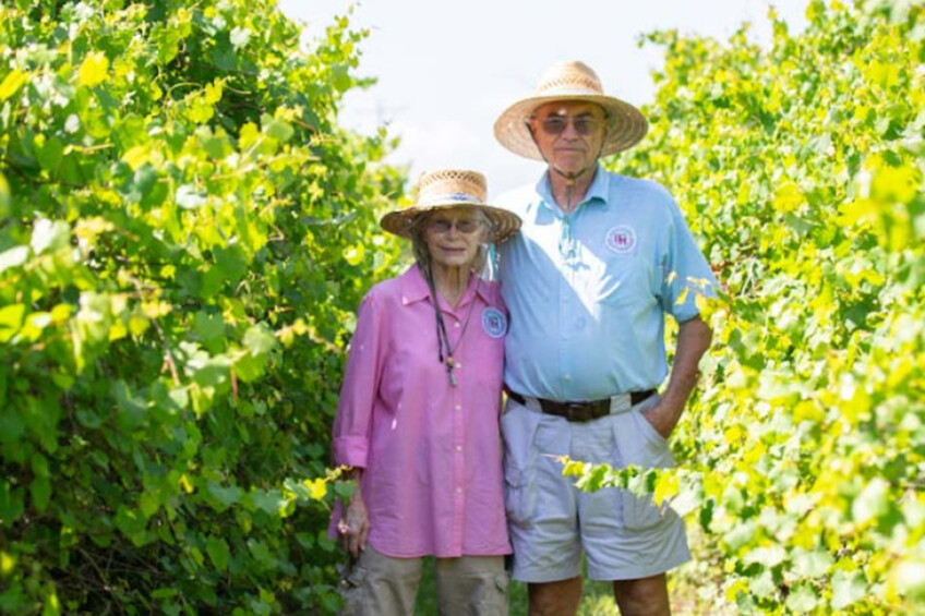 Larry and Lenora Woodham, owners of Bunker Hill Vineyard & Winery, standing among the grapevines