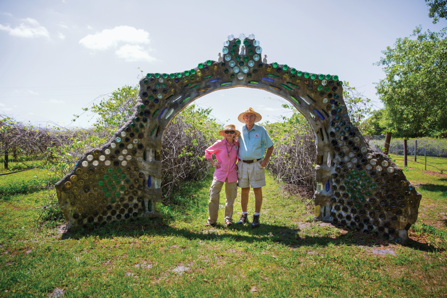 Larry and Lenora Woodham stand under the eco-designed wine bottle wedding arch at Bunker Hill Vineyard & Winery