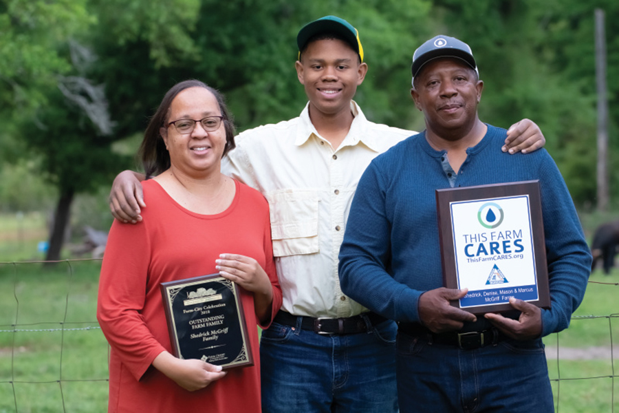 Denise, Mason, Shedrick McGriff holding the 2018 Jackson County Farm Bureau Family Farm of the Year award