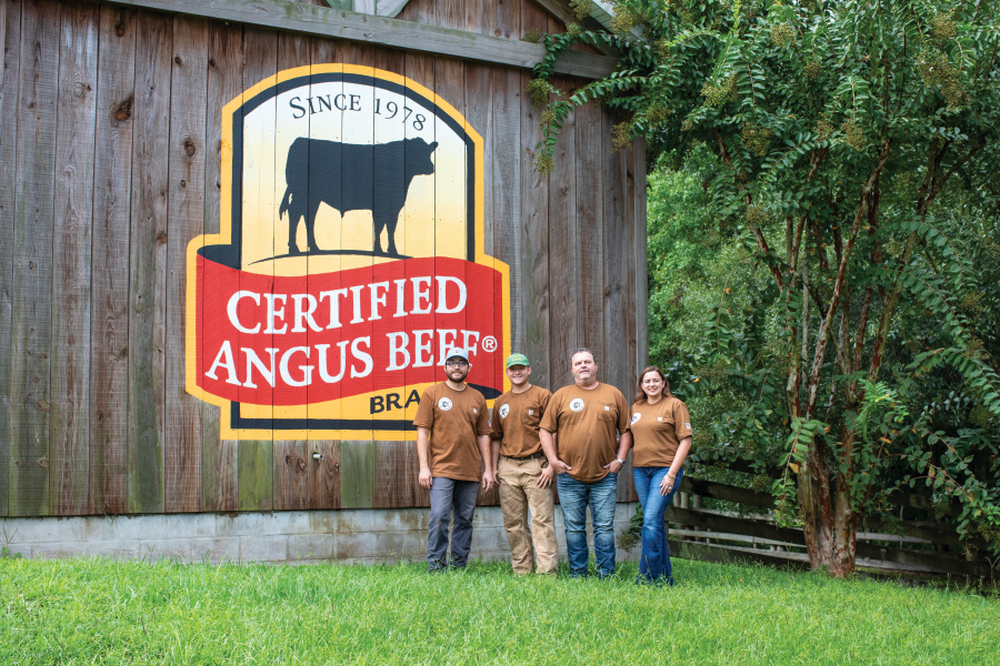 Zac, Sam, Richie and Kelley Longanecker in front of their barn that has the Certified Angus Beef logo painted on it